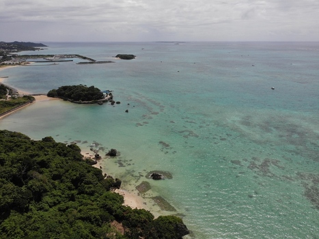 Aerial view of the coastline in the Hyakume area featuring emerald green sea white sandy beach and lush greenery in Nanjo Okinawa Japan. Aerial view of the coastline in the Hyakume area featuring emerald green sea white sandy beach and lush greenery in Nanjo Okinawa Japan.