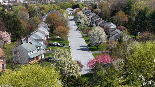 Aerial view of a quiet suburban street lined with houses and blooming spring trees in East Petersburg Pennsylvania United States.