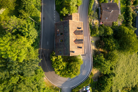 Aerial view of the historic building in Glion situated on a sharp road curve surrounded by lush trees and greenery in Montreux Vaud Switzerland. Aerial view of the historic building in Glion situated on a sharp road curve surrounded by lush trees and greenery in Montreux Vaud Switzerland.