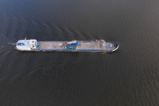 Aerial view of a cargo ship transporting sand through the calm waters of Harderhaven in Zeewolde Flevoland Netherlands.