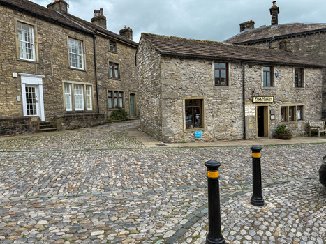 View of the historic stone buildings of the Folk Museum along a cobblestone street Hawes England United Kingdom. View of the historic stone buildings of the Folk Museum along a cobblestone street Hawes England United Kingdom.