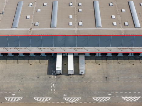 Aerial view of a logistics center with semi trailers at loading bays warehouse roof with skylights and marked pedestrian paths in Warszawa Wojewodztwo mazowieckie Poland. Aerial view of a logistics center with semi trailers at loading bays warehouse roof with skylights and marked pedestrian paths in Warszawa Wojewodztwo mazowieckie Poland.