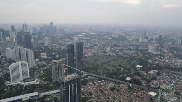 Aerial view of Jakarta Pusat skyscrapers and dense urban sprawl in Menteng Daerah Khusus Ibukota Indonesia. Aerial view of Jakarta Pusat skyscrapers and dense urban sprawl in Menteng Daerah Khusus Ibukota Indonesia.