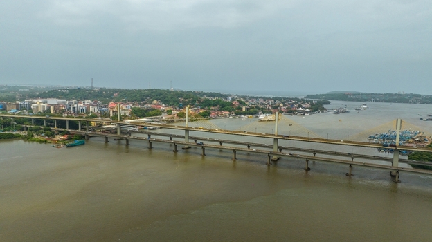 Aerial view of the Atal Setu Goa cable stayed bridge spanning the Mandovi River with the cityscape of Panaji in the background under an overcast sky in Panaji Goa India.