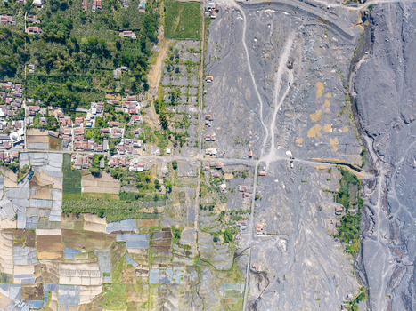 Aerial view of the aftermath of Mount Semeru s volcanic eruption showing the contrast between Supiturang Village and the vast grey path of volcanic ash in Pronojiwo East Java Indonesia.
