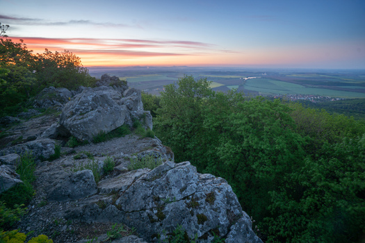 View of Havrania skala in the Male Karpaty mountains with rocky cliffs and lush green forest under a colorful sunset sky Smolenice Trnava Region Slovakia. View of Havrania skala in the Male Karpaty mountains with rocky cliffs and lush green forest under a colorful sunset sky Smolenice Trnava Region Slovakia.