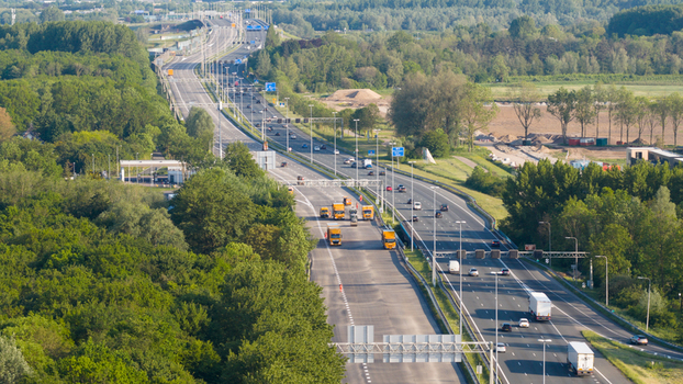 Waardenburg Netherlands 09 May 2026 Aerial view of the A2 motorway with cars and trucks driving through lush green forests and rural landscapes under bright sunlight. Waardenburg Netherlands 09 May 2026 Aerial view of the A2 motorway with cars and trucks driving through lush green forests and rural landscapes under bright sunlight.