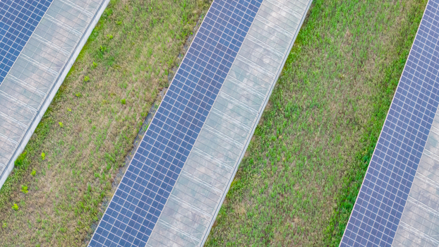 Aerial view of modern agricultural greenhouses with rooftop solar panels showcasing geometric agrivoltaic infrastructure for sustainable farming in Loriol sur Drome Auvergne Rhone Alpes France.