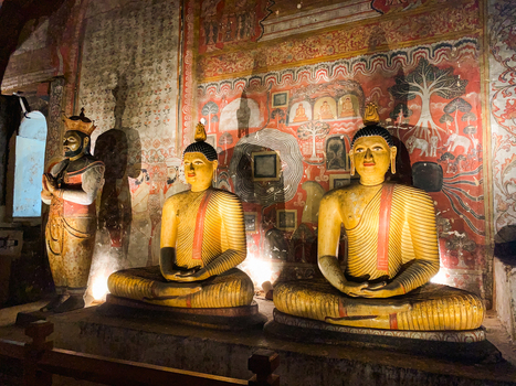 Sri Lanka 20 April 2024 View of the interior of the Dambulla Cave Temple featuring golden seated Buddha statues and intricate ancient wall paintings.