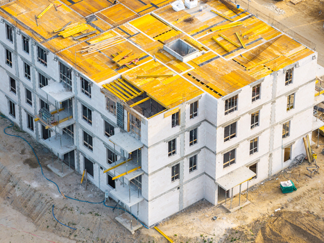 Aerial view of a residential building under construction with yellow roof formwork and white concrete walls in Kowale Pomeranian Voivodeship Poland. Aerial view of a residential building under construction with yellow roof formwork and white concrete walls in Kowale Pomeranian Voivodeship Poland.
