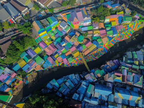 Aerial view of Kampung Warna Warni Jodipan featuring vibrant multi colored houses and painted pathways along the river in Kecamatan Blimbing Jawa Timur Indonesia. Aerial view of Kampung Warna Warni Jodipan featuring vibrant multi colored houses and painted pathways along the river in Kecamatan Blimbing Jawa Timur Indonesia.