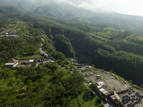 Aerial view of Tambang Pasir Merapi Kali Gendol Sand Mine surrounded by lush tropical forests and a deep valley in Kecamatan Cangkringan Daerah Istimewa Yogya Indonesia. Aerial view of Tambang Pasir Merapi Kali Gendol Sand Mine surrounded by lush tropical forests and a deep valley in Kecamatan Cangkringan Daerah Istimewa Yogya Indonesia.