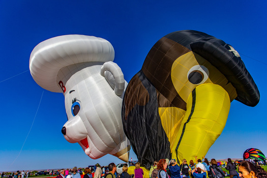 Albuquerque United States 09 October 2017 View of vibrant hot air balloons including a Pillsbury Doughboy and a toucan soaring against a clear blue sky captivating the crowd below.