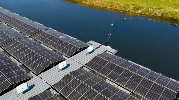 Aerial view of floating solar panels on a water reservoir with green banks under bright sunlight in Zwolle Overijssel Netherlands. Aerial view of floating solar panels on a water reservoir with green banks under bright sunlight in Zwolle Overijssel Netherlands.