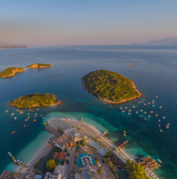 Aerial view of the Ksamil islands and beach with turquoise waters sun loungers and small boats in the Ionian Sea Ksamil Vlore County Albania. Aerial view of the Ksamil islands and beach with turquoise waters sun loungers and small boats in the Ionian Sea Ksamil Vlore County Albania.