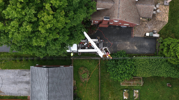 Neffsville Pennsylvania United States 09 July 2026 Aerial view of a utility truck repairing power lines in Manheim Township following a thunderstorm with workers in a bucket lift and residential rooftops visible.