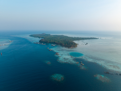Aerial view of Menjangan Besar Island featuring shark breeding enclosures surrounded by turquoise coral reefs and clear blue ocean waters in Karimunjawa Jawa Tengah Indonesia.
