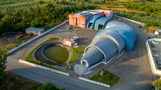 Vila Nova de Oliveirinha Portugal Aerial view of the Bombeiros Voluntarios fire station with its unique curved roof structure like a fire hose adjacent pond and surrounding rural landscape. Vila Nova de Oliveirinha Portugal Aerial view of the Bombeiros Voluntarios fire station with its unique curved roof structure like a fire hose adjacent pond and surrounding rural landscape.