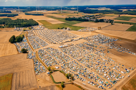 Aerial view of Open Beatz Festival grounds with thousands of tents parked cars and surrounding agricultural fields Herzogenaurach Bayern Germany. Aerial view of Open Beatz Festival grounds with thousands of tents parked cars and surrounding agricultural fields Herzogenaurach Bayern Germany.
