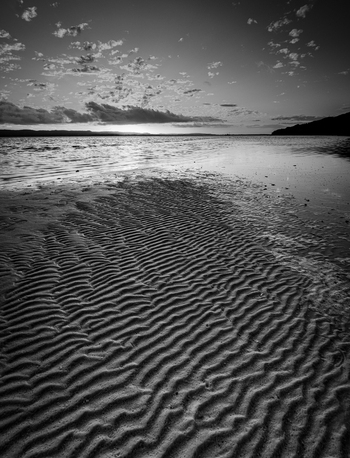 View of rippled sand patterns on the shore of Quaranup Beach at sunset with calm water and a cloudy sky Vancouver Peninsula Western Australia Australia. View of rippled sand patterns on the shore of Quaranup Beach at sunset with calm water and a cloudy sky Vancouver Peninsula Western Australia Australia.