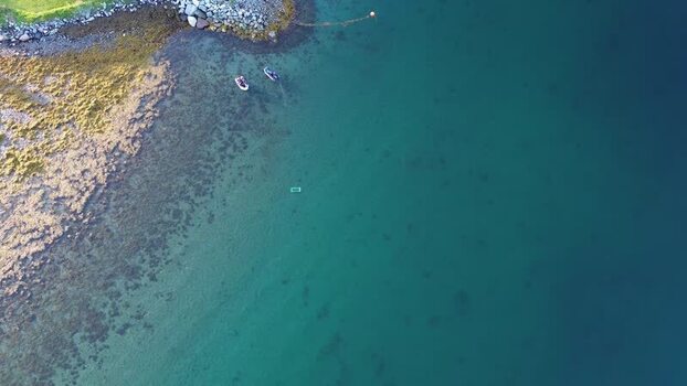 Aerial view of Senja coastline with boats Norway.