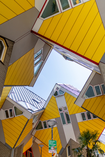 View of the iconic yellow Cube Houses with their unique geometric architecture under a clear blue sky in Rotterdam South Holland Netherlands. View of the iconic yellow Cube Houses with their unique geometric architecture under a clear blue sky in Rotterdam South Holland Netherlands.