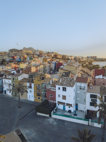 Aerial view of colorful houses palm trees and the Mediterranean coastline under a clear sky in La Vila Joiosa Valencian Community Spain. Aerial view of colorful houses palm trees and the Mediterranean coastline under a clear sky in La Vila Joiosa Valencian Community Spain.