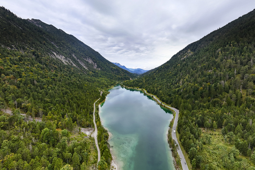 Aerial view of a serene lake nestled between lush verdant forests and towering mountains Plansee Tyrol Austria. Aerial view of a serene lake nestled between lush verdant forests and towering mountains Plansee Tyrol Austria.