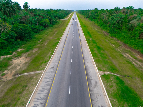 Aerial view of the long straight road on Bonny Island surrounded by lush tropical vegetation and palm trees in Bonny Town Rivers Nigeria. Aerial view of the long straight road on Bonny Island surrounded by lush tropical vegetation and palm trees in Bonny Town Rivers Nigeria.