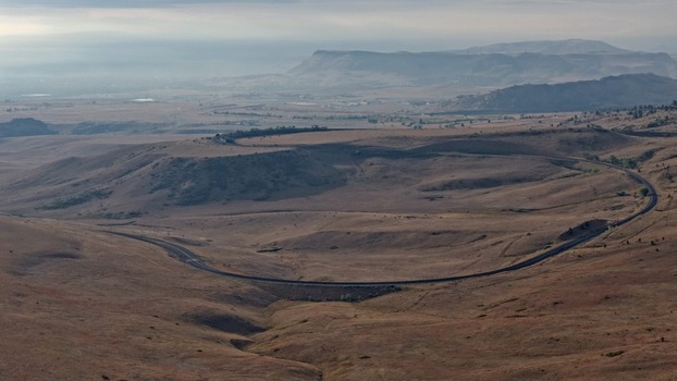 Aerial view of the Big Ten Curve railroad tracks winding through the dry grassy foothills of the Rocky Mountains near Golden Colorado United States.