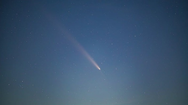 View of a bright comet in the night sky over Latvia.