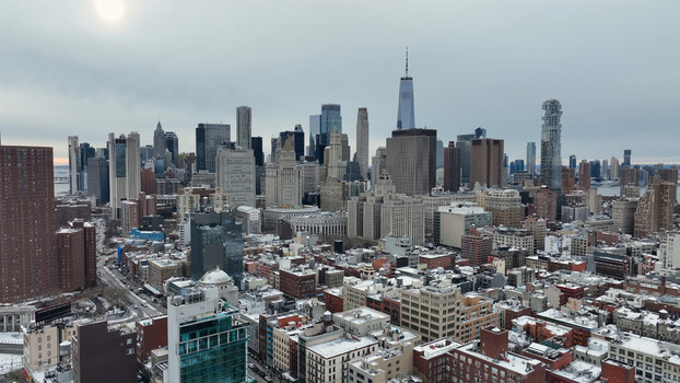 Aerial view of the Manhattan skyline with snow covered rooftops and skyscrapers under a cloudy sky in New York New York United States. Aerial view of the Manhattan skyline with snow covered rooftops and skyscrapers under a cloudy sky in New York New York United States.