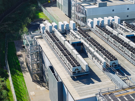 Aerial view of a data center roof featuring rows of industrial cooling units and HVAC systems on a modern facility in the United Kingdom.