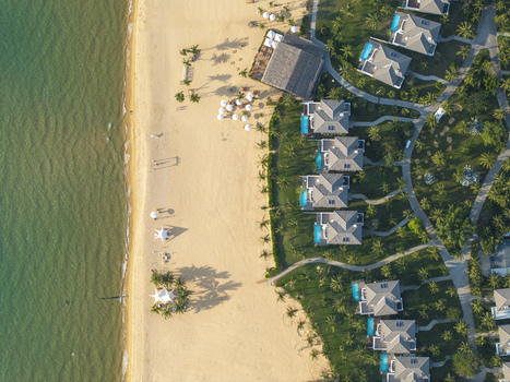 Aerial view of a luxury beach resort with private villas swimming pools and golden sand along the turquoise coastline in Phu Quoc Vietnam. Aerial view of a luxury beach resort with private villas swimming pools and golden sand along the turquoise coastline in Phu Quoc Vietnam.