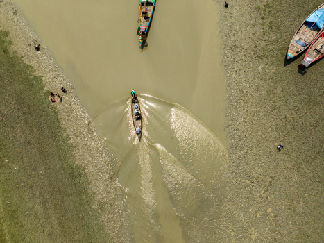Aerial view of boats sailing on the tranquil river their wakes creating mesmerizing patterns on the water s surface Charmonai Barisal Division Bangladesh. Aerial view of boats sailing on the tranquil river their wakes creating mesmerizing patterns on the water s surface Charmonai Barisal Division Bangladesh.