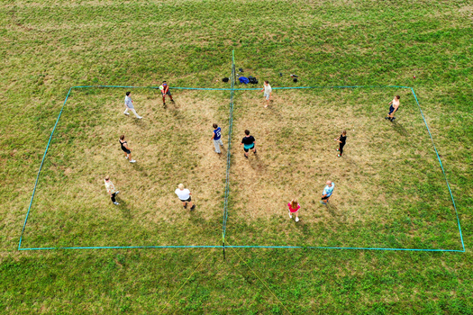 Herzogenaurach Germany 26 July 2025 Aerial view of people playing volleyball on a grass court during the Open Beatz Festival with green fields and summer light.