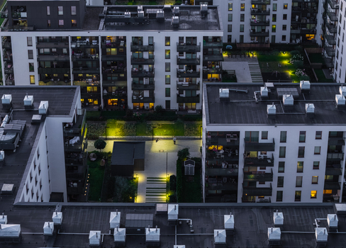 Aerial view of modern residential apartment buildings in the Oliwa district with illuminated walkways and green courtyards at dusk in Gdansk Pomeranian Voivodeship Poland. Aerial view of modern residential apartment buildings in the Oliwa district with illuminated walkways and green courtyards at dusk in Gdansk Pomeranian Voivodeship Poland.