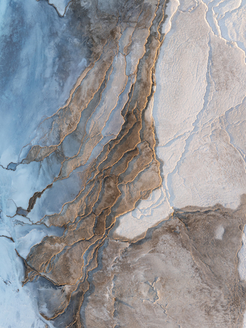 Aerial view of the geothermal landscape of Reykjanes with intricate mineral deposits textured brown terrain and white silica formations in Grindavikurbaer Iceland. Aerial view of the geothermal landscape of Reykjanes with intricate mineral deposits textured brown terrain and white silica formations in Grindavikurbaer Iceland.