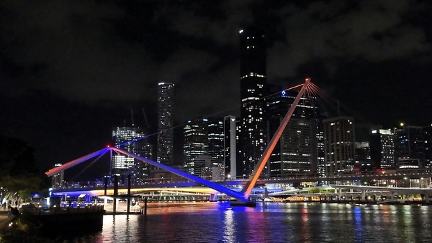 View of the illuminated Kurilpa Bridge spanning the Brisbane River with the modern city skyline glowing in the night Brisbane Queensland Australia. View of the illuminated Kurilpa Bridge spanning the Brisbane River with the modern city skyline glowing in the night Brisbane Queensland Australia.