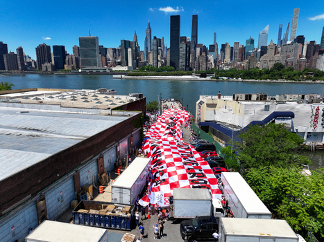 Long Island City United States 13 June 2026 Aerial view of a massive red and white checkered Croatian flag held by fans in the streets with Manhattan skyline behind.