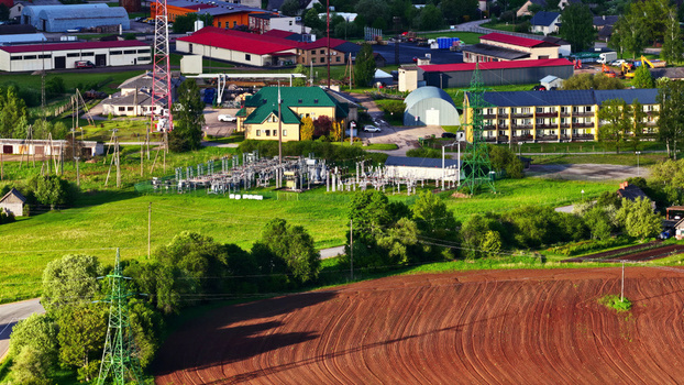 Aerial view of an electrical substation surrounded by industrial buildings green fields and a plowed field in Latvia. Aerial view of an electrical substation surrounded by industrial buildings green fields and a plowed field in Latvia.