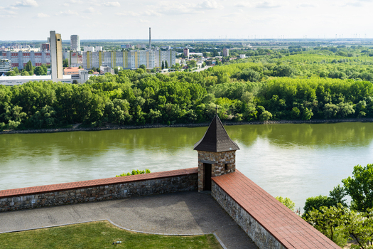 View of the stone fortification walls and a small turret of Bratislava Castle overlooking the Danube River and the city skyline in Bratislava Bratislava Region Slovakia. View of the stone fortification walls and a small turret of Bratislava Castle overlooking the Danube River and the city skyline in Bratislava Bratislava Region Slovakia.