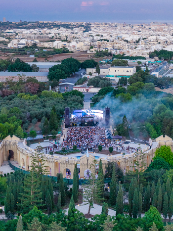 Attard Malta 20 September 2026 Aerial view of Park Nazzjonali Ta Qali hosting an outdoor concert with a large crowd gathered in front of the stage surrounded by trees. Attard Malta 20 September 2026 Aerial view of Park Nazzjonali Ta Qali hosting an outdoor concert with a large crowd gathered in front of the stage surrounded by trees.