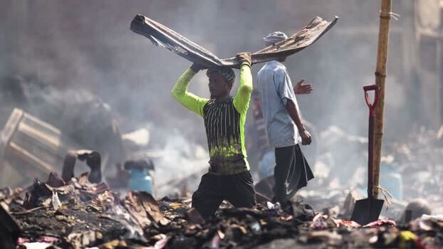 View of a man carrying debris through smoke in Dhaka Bangladesh. View of a man carrying debris through smoke in Dhaka Bangladesh.