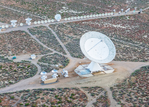 Aerial view of the Owens Valley Radio Observatory featuring large satellite dishes across the desert landscape in Inyo County California United States.