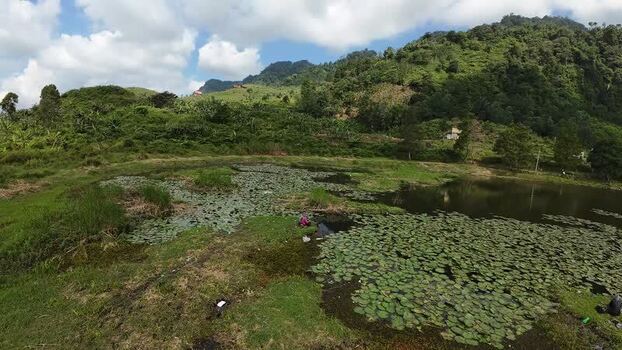 Aerial view of Rawa Gede Jonggol Lake and green hills Indonesia.