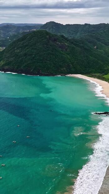 Aerial view of the coastline and lush hills in Bali Indonesia.