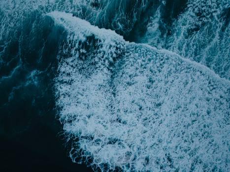 Aerial view of a powerful ocean wave breaking with white sea foam and deep blue water in San Diego California United States. Aerial view of a powerful ocean wave breaking with white sea foam and deep blue water in San Diego California United States.
