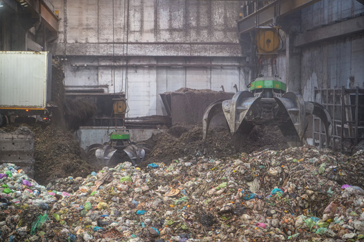 View of mechanical grabbers handling large piles of organic waste inside the Forsu Iren treatment plant in Reggio nell Emilia Emilia Romagna Italy. View of mechanical grabbers handling large piles of organic waste inside the Forsu Iren treatment plant in Reggio nell Emilia Emilia Romagna Italy.