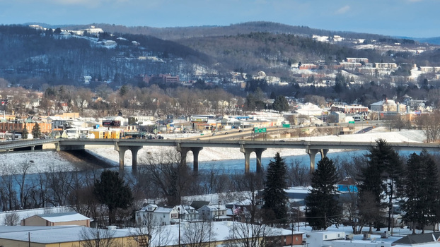 Aerial view of the bridge spanning the Susquehanna River surrounded by snow covered hills and urban buildings in Williamsport Pennsylvania United States.